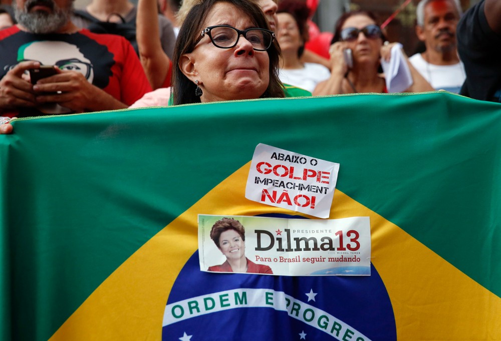 Une manifestante tenant un drapeau avec écrit en portugais sur un autocollant « A bas le coup d'État, non à la destitution » lors d'une manifestation de soutien à la présidente du Brésil Dilma Rousseff et de l'ancien président Luiz Inacio Lula da Silva à Sao Paulo, au Brésil, 31 mars 2016. Photo: Andre Penner/AP