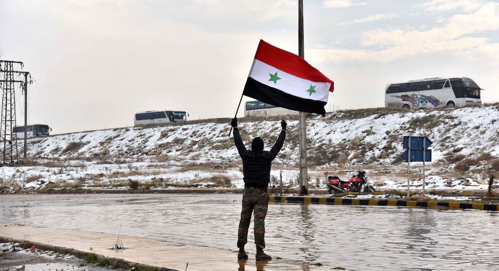 Illustration. Ici, un homme agite un drapeau syrien alors que des membres de l'opposition sont évacués d'Alep dans un convoi - CHINE NOUVELLE/SIPA